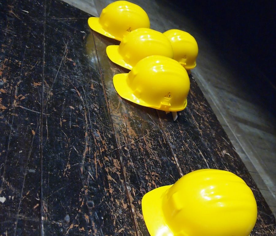 five yellow hard hats on gray surface